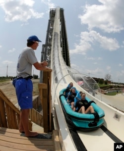 FILE - In this photo taken with the fisheye lens, riders go down the world's tallest water slide called "Verruckt" at Schlitterbahn Waterpark in Kansas City, Kan., July 9, 2014.