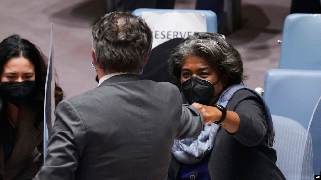 Ukraine's United Nations Ambassador Sergiy Kyslytsya, center, fist-bumps U.S. Ambassador Linda Thomas-Greenfield, left, after a Security Council meeting at U.N. headquarters, Jan. 31, 2022. (AP Photo/Richard Drew)