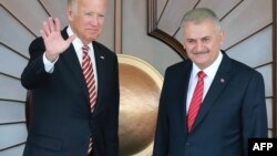 Turkish Prime Minister Binali Yildirim (R) as US Vice President Joe Biden waves as they pose for a photograph before their meeting at Cankaya Palace in Ankara, Aug. 24, 2016.