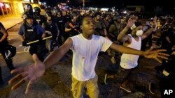 FILE - Police disperse demonstrators protesting the shooting death of unarmed black teenager Michael Brown in Ferguson, Missouri, Aug. 20, 2014. 