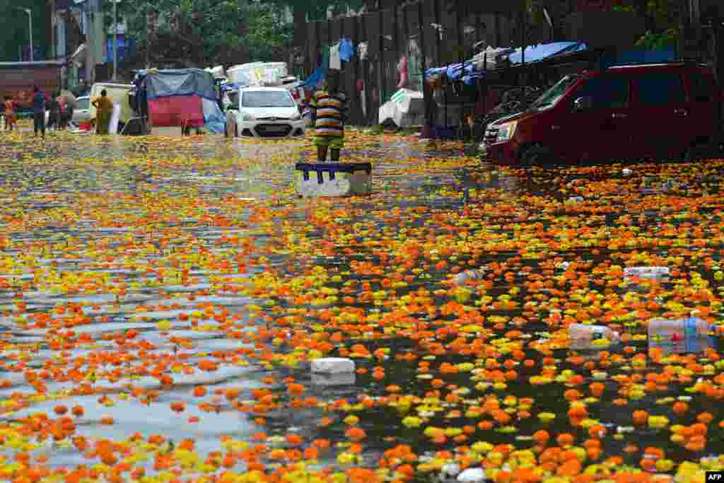 A vendor stands in a flooded flower market following heavy monsoon rains in Mumbai, India.