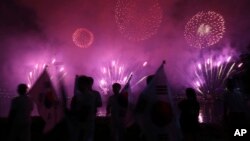 Quelques personnes regardent les feux d'artifice lors d'un événement pour marquer le début du compte à rebours de 500 jours avant les Jeux d'hiver olympiques Séoul 2018 à PyeongChang, Corée du Sud, 27 septembre 2016. 