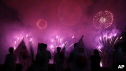 Quelques personnes regardent les feux d'artifice lors d'un événement pour marquer le début du compte à rebours de 500 jours avant les Jeux d'hiver olympiques Séoul 2018 à PyeongChang, Corée du Sud, 27 septembre 2016. 