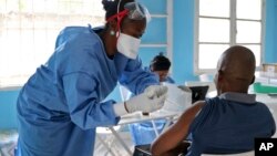 世界卫生组织救护工作人员2018年5月30号在刚果的姆班达卡为人注射埃博拉病毒疫苗
