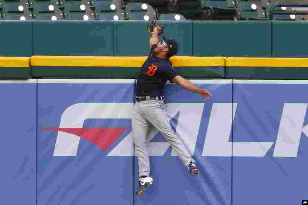 Detroit Tigers baseball player Riley Greene catches a ball over the outfield wall to save a home run during an intrasquad baseball game in Detroit, Michigan.