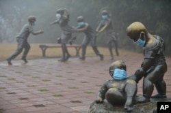2017年1月4日，河南濮阳，在雾霾里，街头雕塑也被戴上口罩