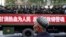 Một người đàn ông Hồi giáo Uighur đang nhìn theo chiếc xe tải chở lực lượng vũ trang bán quân sự trên đường phố trong một chiến dịch chống khủng bố của chính quyền Trung Quốc ở Tân Cương.