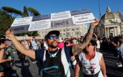 FILE - Protesters demonstrate against the Green Pass plan (health pass) that has become mandatory to access an array of services and leisure activities, in Rome, Italy, Aug. 7, 2021.