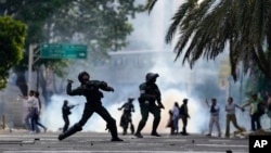 ARCHIVO - Un policía lanza una bomba lacrimógena durante protestas contra los controvertidos resultados electorales en Venezuela, el 29 de julio de 2024, en Caracas. Hay más de 1.800 presos políticos en el país, según varias ONG.