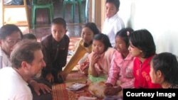 Fred Bemak, left front, talks with Burmese children post-cyclone. (Courtesy of Fred Bemak and Rita Chung)