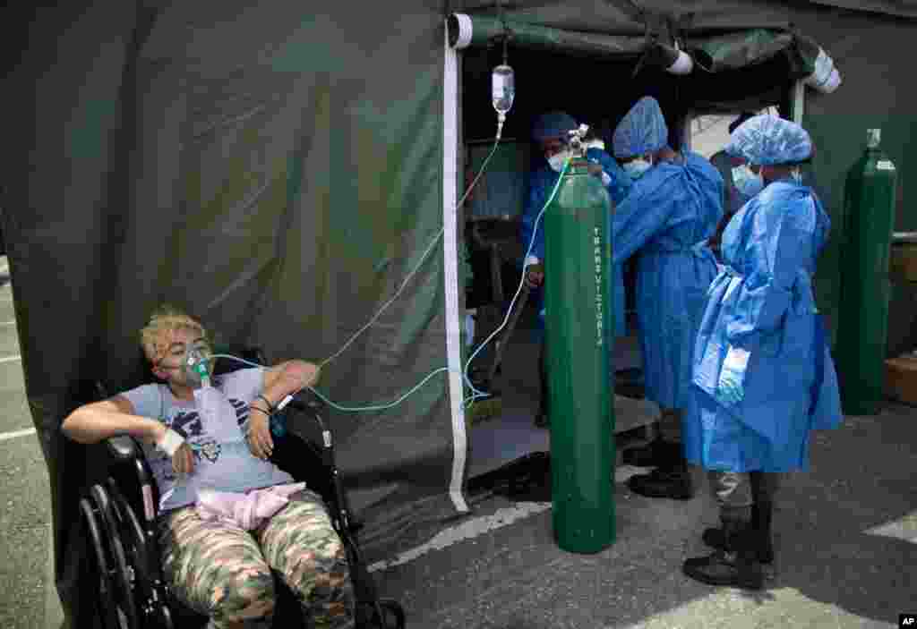 A woman who suffers from COVID-19, receives oxygen at a field hospital set up in the parking lot of the Poliedro de Caracas auditorium, in Venezuela, March 21, 2021.