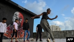 FILE - In this July 2, 2021, photo, a student performs during a group class to learn breaking or 'b-boying' at a training session on the rooftop of a building in Dharavi slums in Mumbai.