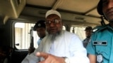 Bangladesh's Jamaat-e-Islami leader Abdul Quader Mollah gestures as he talks from a police van after a war crimes tribunal sentenced him to life imprisonment in Dhaka February 5, 2013. A controversial war crimes tribunal sentenced a senior leader of Bangl