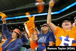 Lifelong Houstonian Brenda Davis, center, waves an Astros foam finger during a watch party at Minute Maid Park. Davis says she lost most of her personal belongings during Hurricane Harvey, but managed to salvage her Astros memorabilia.