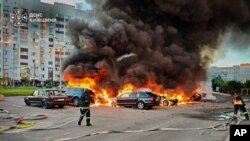Пожарные тушат автомобили после атаки российских беспилотников в Киевской области 28 августа 2026 года. (Фото: AP/Государственная служба Украины по чрезвычайным ситуациям)