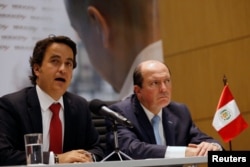 From left, Christian Kruger, Colombia's Migration Director and Eduardo Sevilla, Peru's Migration Superintendent, speak at a news conference in Bogota, Colombia, Aug. 28, 2018.