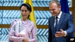 State Counselor of Myanmar Aung San Suu Kyi, left, is greeted by European Council President Donald Tusk at the Europa building in Brussels on May 2, 2017.