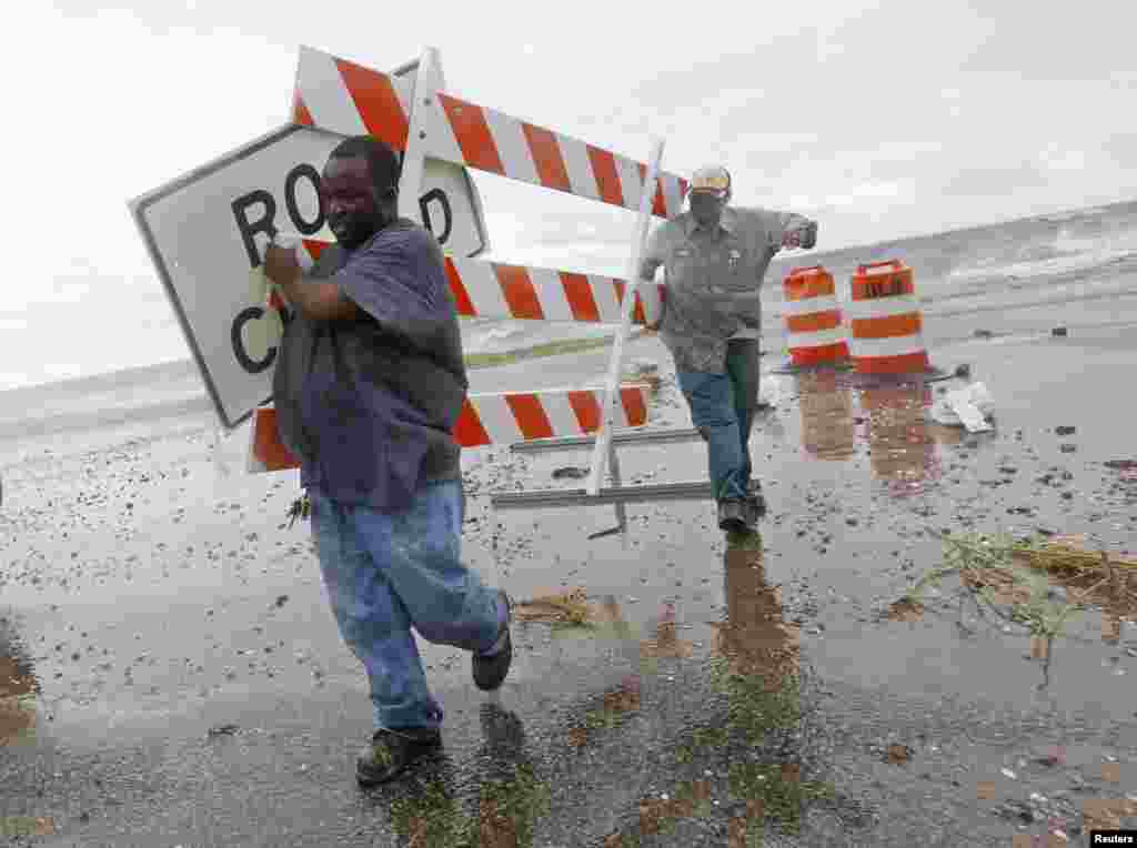 Employees of the Orleans Levee District remove signs from Lake Shore Dr. near the shore of Lake Pontchartrain as tropical storm Isaac approaches New Orleans, August 28, 2012.