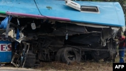 FILE: People inspect the wreckage of one of two buses that collided Nov. 7, 2018, along the Harare-Mutare highway near Rusape, Zimbabwe, Nov. 8, 2018.