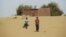 Boys walk on desert sands in the town of Moghtar-Lajjar in west Africa's Sahel region, where the United Nations says civil unrest and a drought have put 18 million people in food insecurity, May 25 2012.