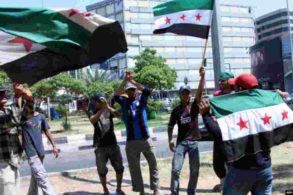 Men celebrate in the Lebanese town of Tripoli on July 18, 2012, after an attack in Damascus killed the Syria&#39;s defense minister, General Daoud Rajha.