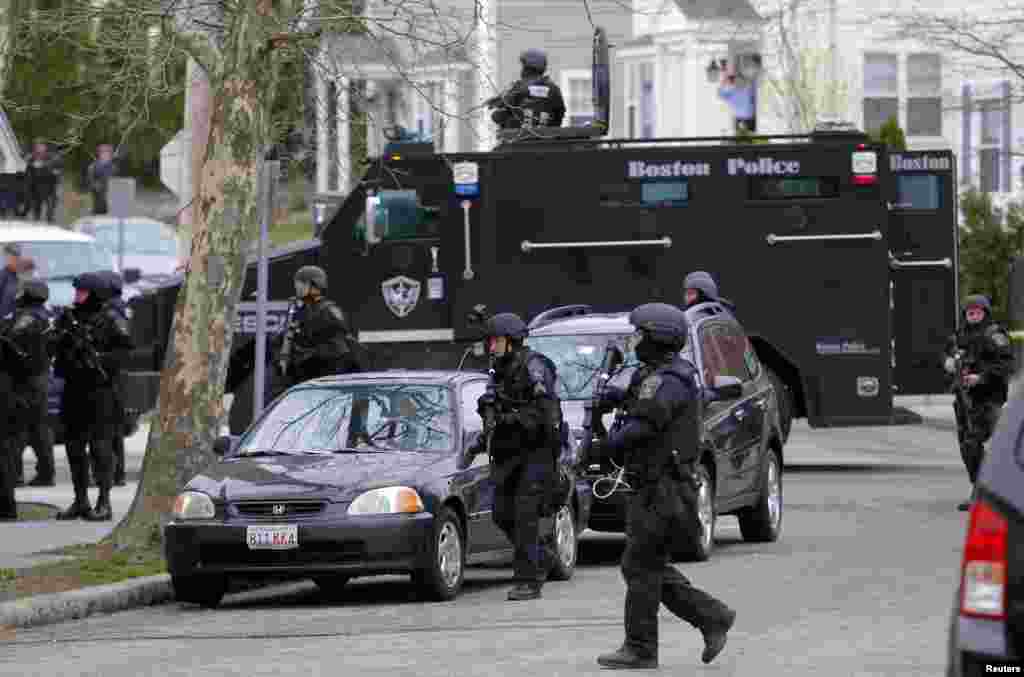 SWAT teams enter a suburban neighborhood searching for the remaining suspect in the Boston Marathon bombings in Watertown, Massachusetts April 19, 2013.