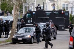 FILE - SWAT teams enter a suburban neighborhood searching for the remaining suspect in the Boston Marathon bombings in Watertown, Massachusetts, April 19, 2013.