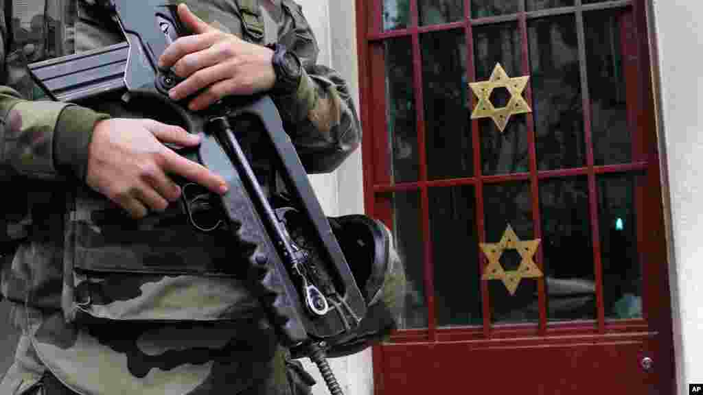 France on Monday ordered 10,000 troops into the streets to protect sensitive sites; a soldier stands guard outside a synagogue in Neuilly sur Seine, outside, Paris, France, Jan. 13, 2015. 