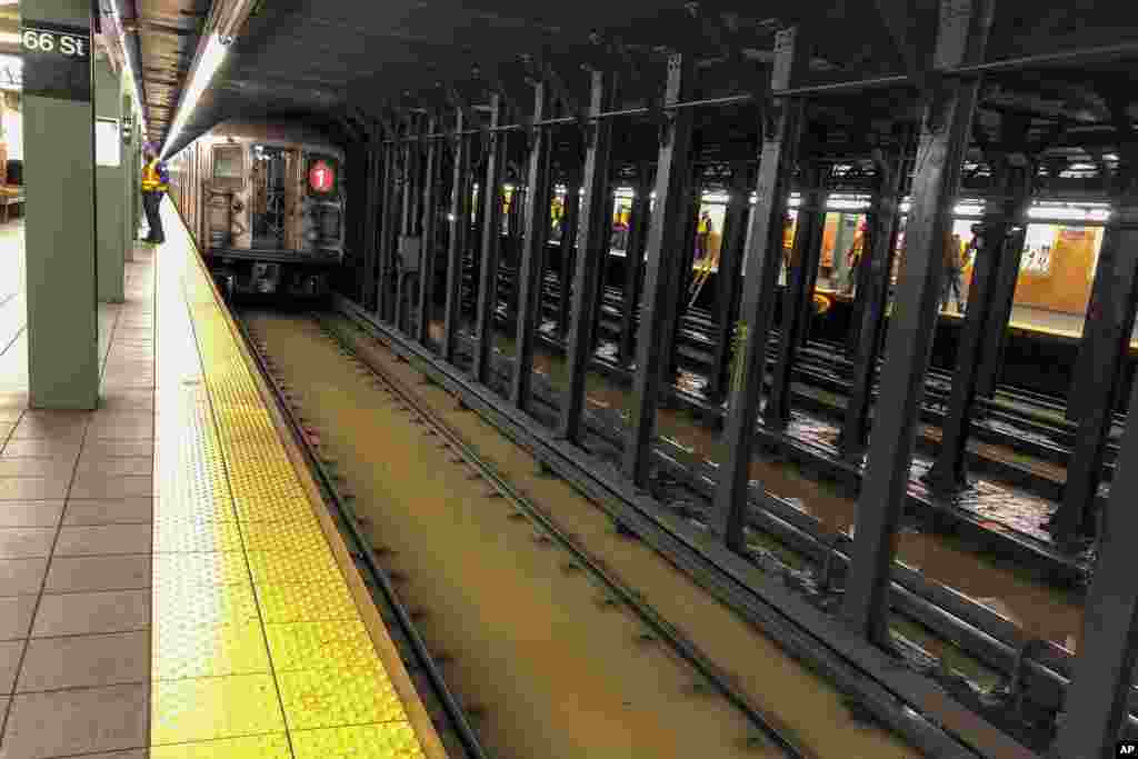 A subway train sits on flooded tracks at 66th Street in New York. A water main break flooded streets on Manhattan&#39;s Upper West Side near Lincoln Center and hampered subway service during the Monday morning rush hour.
