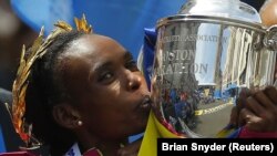 Rita Jeptoo du Kenya porte le trophée après sa victoire au 118e marathon de Boston version féminine, à Boston, Massachusetts, 21 avril 2014. REUTERS / Brian Snyder