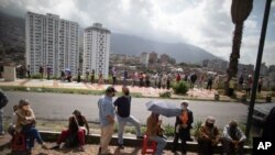 Personas hacen fila junto a una cancha de baloncesto en el barrio 23 de Enero para vacunarse durante una campaña de vacunación COVID-19 en Caracas, el 9 de junio de 2021.
