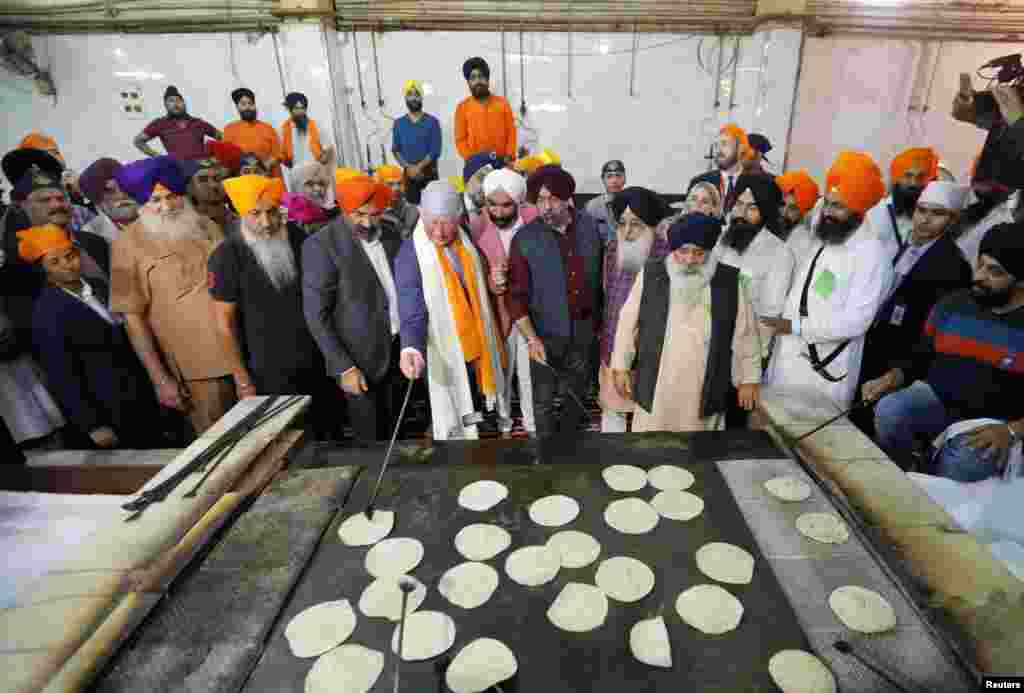 Britain&#39;s Prince Charles prepares bread at a community kitchen during his visit to a Gurudwara (Sikh temple) in New Delhi, India.