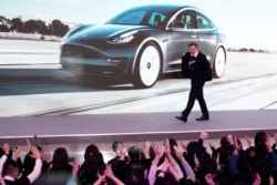 Tesla Inc CEO Elon Musk takes off his coat onstage during a delivery event for Tesla China-made Model 3 cars in Shanghai, China, Jan. 7, 2020.