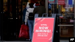 FILE - Hiring sign is displayed outside of a retail store in Vernon Hills, Illinois, Nov. 13, 2021. 