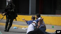 A father challenges a security forces member and prevents him from detaining his son during clashes with anti-government protesters who were trying to march to the Supreme Court, in Caracas, Venezuela, July 6, 2017. 