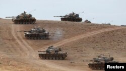 Türkiyə tankları Suriya ilə sərhəd Şanlıurfa bölgəsinin Suruc qəsəbəsində Kobane şəhərinə baxan təpəlikdə mövqe tuturlar. 29 sentyabr, 2014.