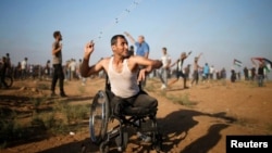 ایک احتجاجی مظاہرے کے دوران ایک معذور فلسطینی غلیل نما آلے سے اسرائیلی فوجیوں پر کنکر بھینک رہا ہے۔