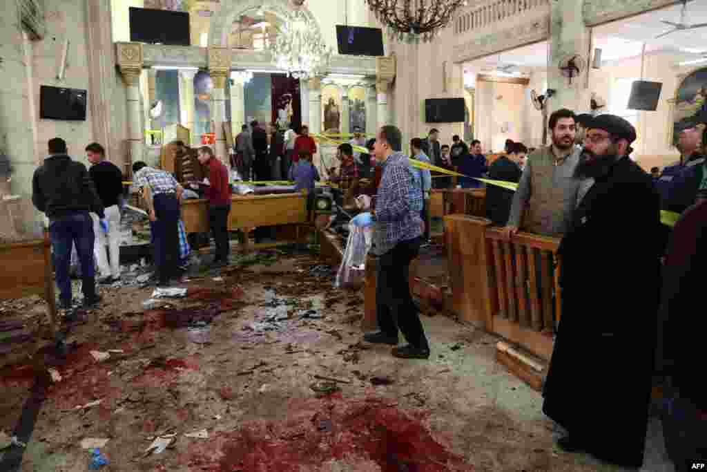 Pessoas dentro da igreja Mar Girgis Copta na cidade de Tanta no Delta do Nilo, olham para o chão ensaguentado após a explosão de uma bomba durante o serviço religioso de celebração do Domingo de Ramos. Tanta fica a 120 quilómetros a norte do Cairo, Abril 9, 2017.