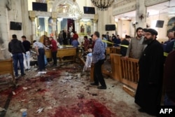 FILE - People look at the aftermath following a bomb blast which struck worshippers gathering to celebrate Palm Sunday at the Mar Girgis Coptic Church in the Nile Delta City of Tanta, 120 kilometres (75 miles) north of Cairo, April 9, 2017.