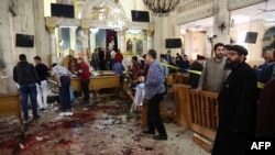 A general view shows people looking at the aftermath following a bomb blast which struck worshippers gathering to celebrate Palm Sunday at the Mar Girgis Coptic Church in the Nile Delta City of Tanta, 120 kilometres (75 miles) north of Cairo, on April 9, 