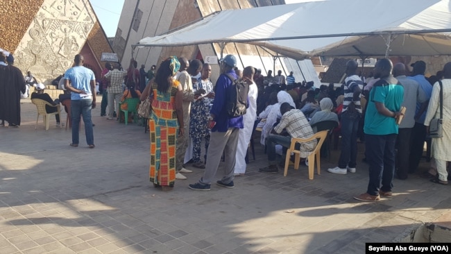 Une centaine de personnes font la queue pour accéder à la salle d'enrôlement à Dakar, au Sénégal, le 14 septembre 2018. (VOA/Seydina Aba Gueye)