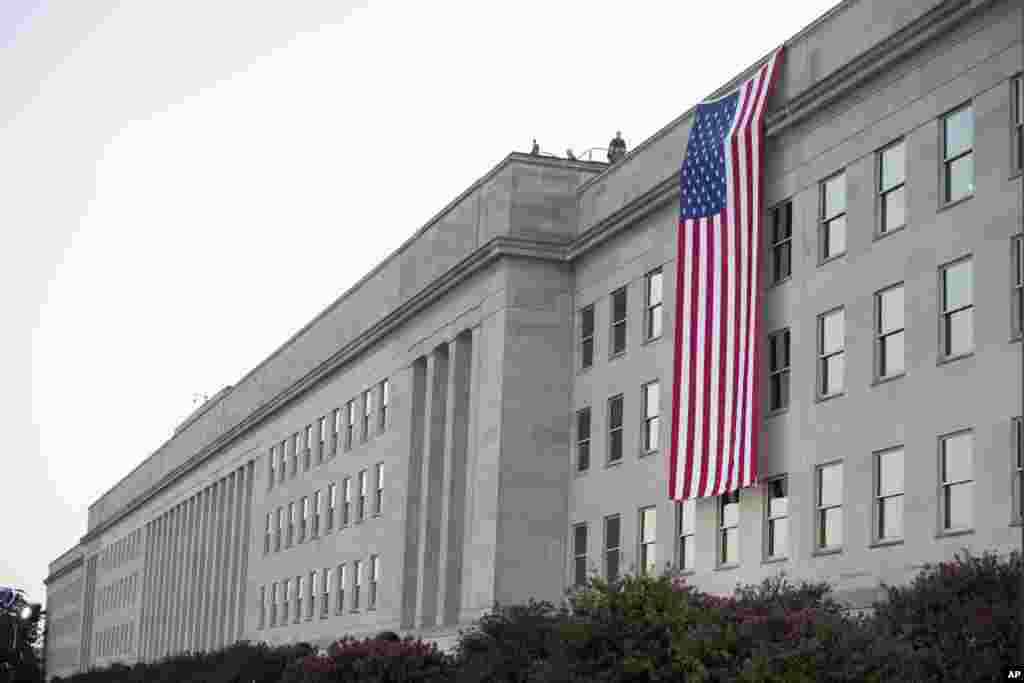 A flag hangs from the top of the Pentagon during a dawn 9/11 remembrance ceremony in Washington, Sept. 11, 2024.