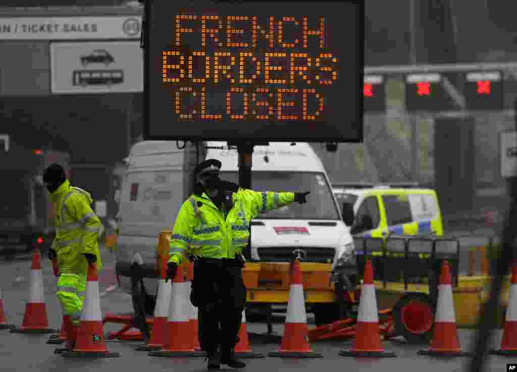 A police officer directs traffic at the entrance to the closed ferry terminal in Dover, England, after the Port of Dover was closed and access to the Eurotunnel terminal suspended following the French government&#39;s announcement.