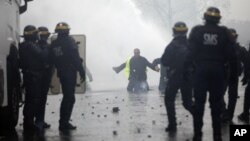 Polisi anti huru-hara bentrok dengan para demonstran 'Rompi Kuning' di Champs-Elysees, Paris. 