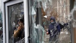 A man takes a photo of windows of a police kiosk damaged by demonstrators during a protest in Almaty, Kazakhstan, Jan. 5, 2022.