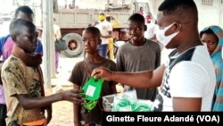 Des masques ont été distribués dans les rues de Cotonou, Bénin, le 1er juillet 2020. (VOA/Ginette Fleure Adandé)