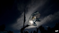 Un manifestante ondea una bandera nacional durante una protesta por el manejo de las vacunas COVID-19, en Buenos Aires, Argentina. Febrero 27, 2021. Foto: AP.