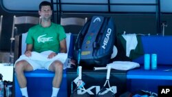 Defending men's champion, Serbia's Novak Djokovic, rests during a practice session on Margaret Court Arena ahead of the Australian Open tennis championship in Melbourne, Australia, Jan. 13, 2022. 