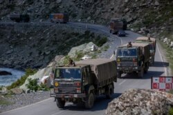 FILE - An Indian army convoy moves on the Srinagar- Ladakh highway at Gagangeer, northeast of Srinagar, Indian-controlled Kashmir, Sept. 9, 2020.