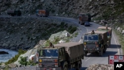An Indian army convoy moves on the Srinagar- Ladakh highway at Gagangeer, northeast of Srinagar, Indian-controlled Kashmir, Sept. 9, 2020.